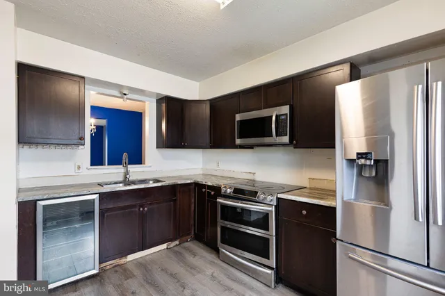 a kitchen with a sink stainless steel appliances and cabinets