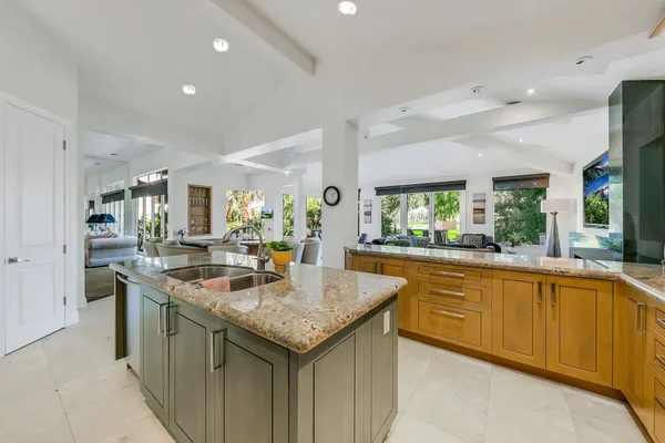 a kitchen with granite countertop kitchen island a sink and a stove in it