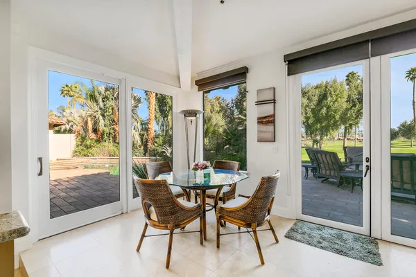 a dining room with furniture a chandelier and glass door