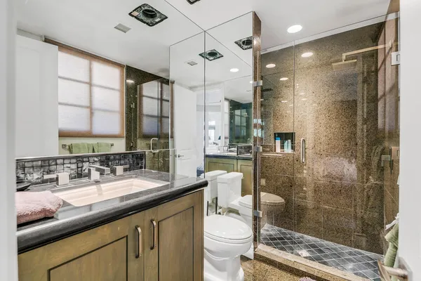 a bathroom with a double vanity sink toilet and shower
