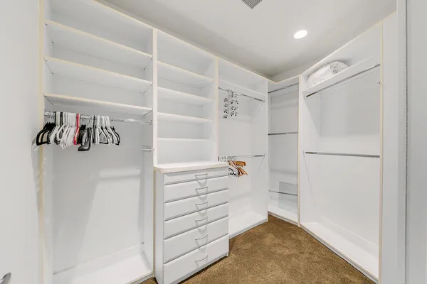 a view of walk in closet with empty racks