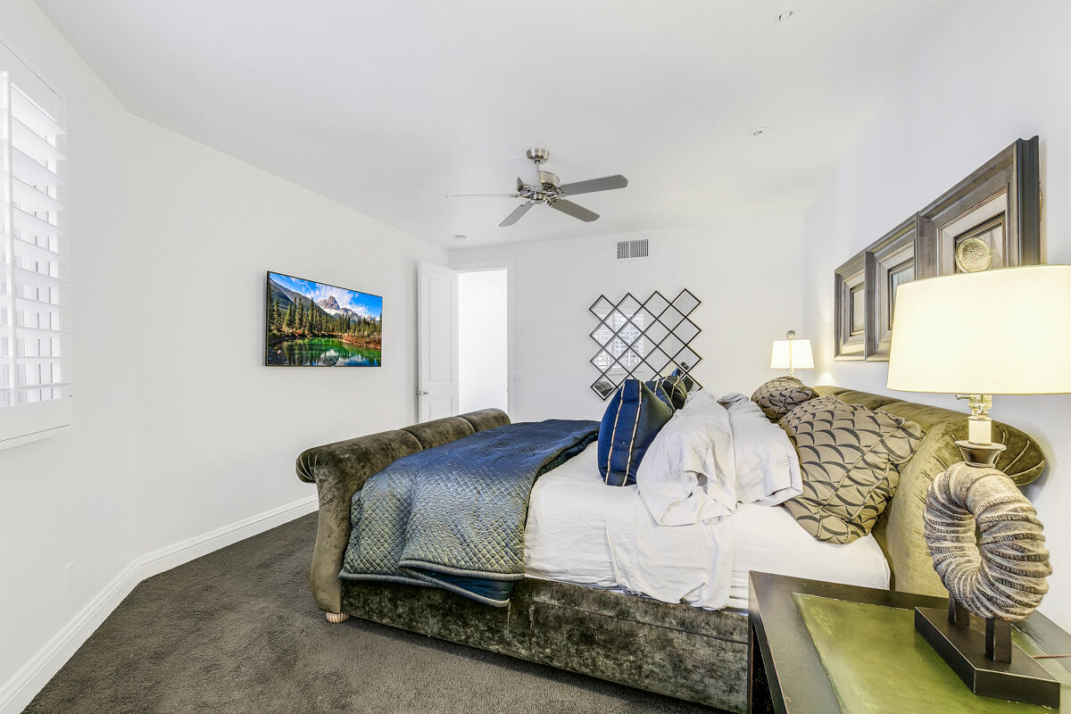 54310 Riviera La Quinta, CA 92253 - Photo 33 of 45 a bedroom with a bed and a chandelier