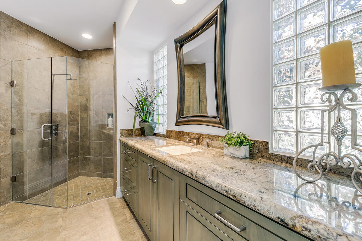54310 Riviera La Quinta, CA 92253 - Photo 34 of 45 a bathroom with a granite countertop sink a mirror and shower