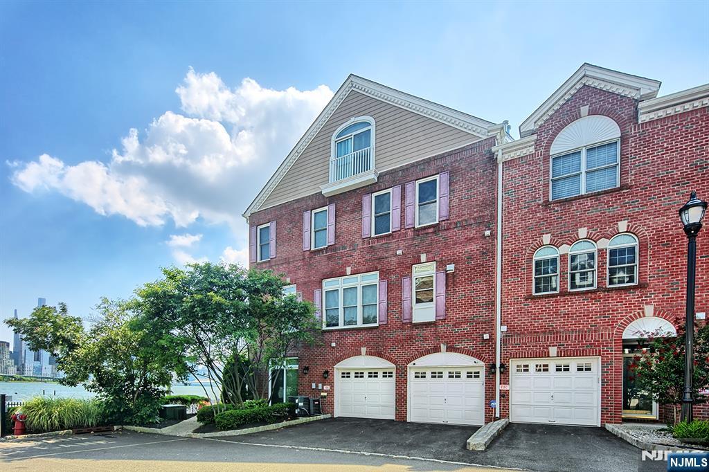 406 Newburgh Court West New York, NJ 07093 - Photo 21 of 31 a front view of a house with a yard and garage