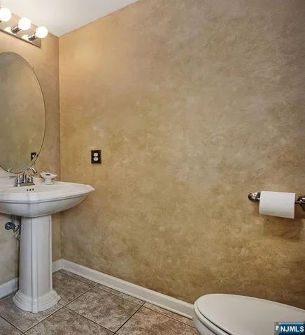 a bathroom with a sink a toilet and mirror