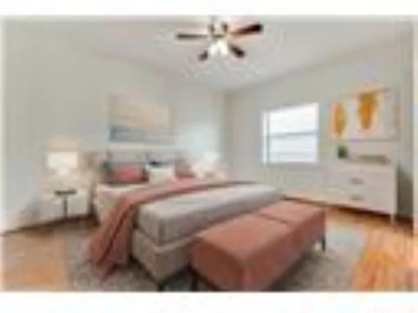 a view of a bedroom with furniture and wooden floor