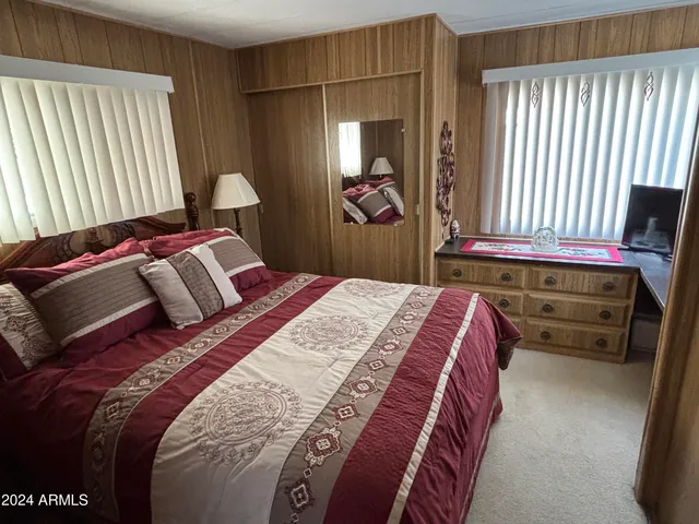 a bedroom with a bed and a large mirror