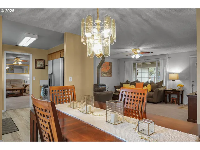 a living room with dining table and a chandelier