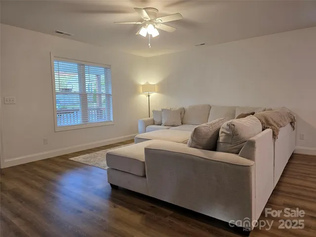 a living room with furniture and a ceiling fan