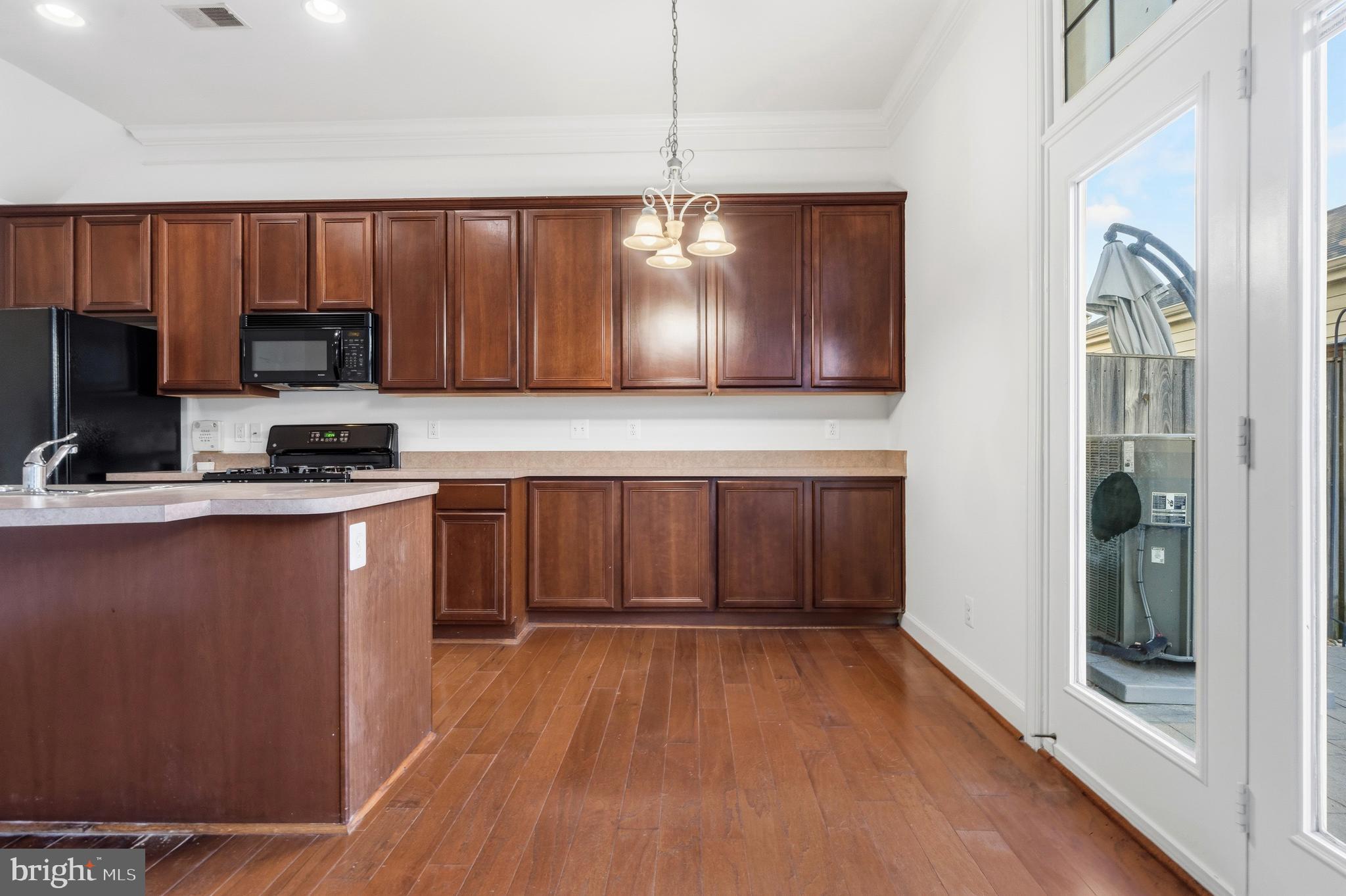9227 Ribbon Falls Loop Bristow, VA 20136 - Photo 28 of 53 a kitchen with granite countertop a stove top oven a sink dishwasher a refrigerator and a microwave oven with wooden floor
