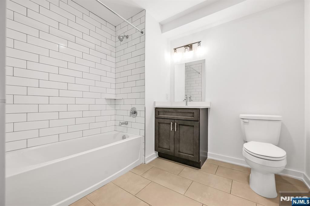 315 Railroad Avenue, Unit 107 East Rutherford, NJ 07073 - Photo 11 of 25 a bathroom with a toilet and a bathtub