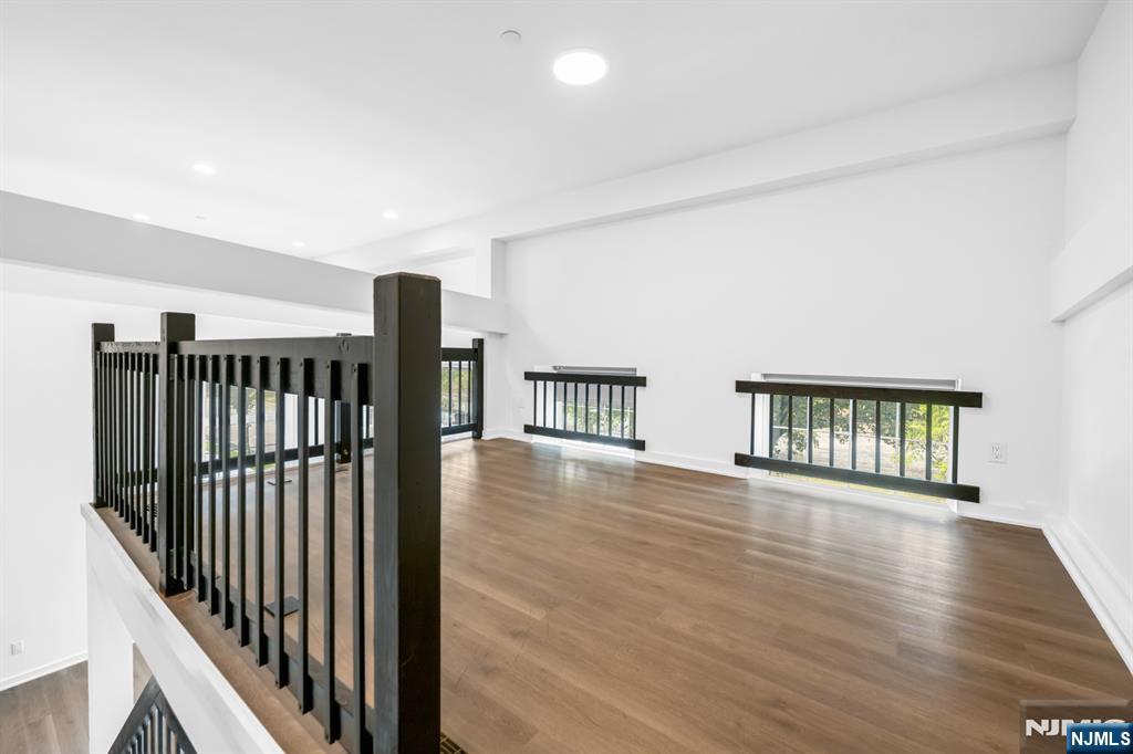 315 Railroad Avenue, Unit 107 East Rutherford, NJ 07073 - Photo 14 of 25 a view of an empty room with wooden floor and windows