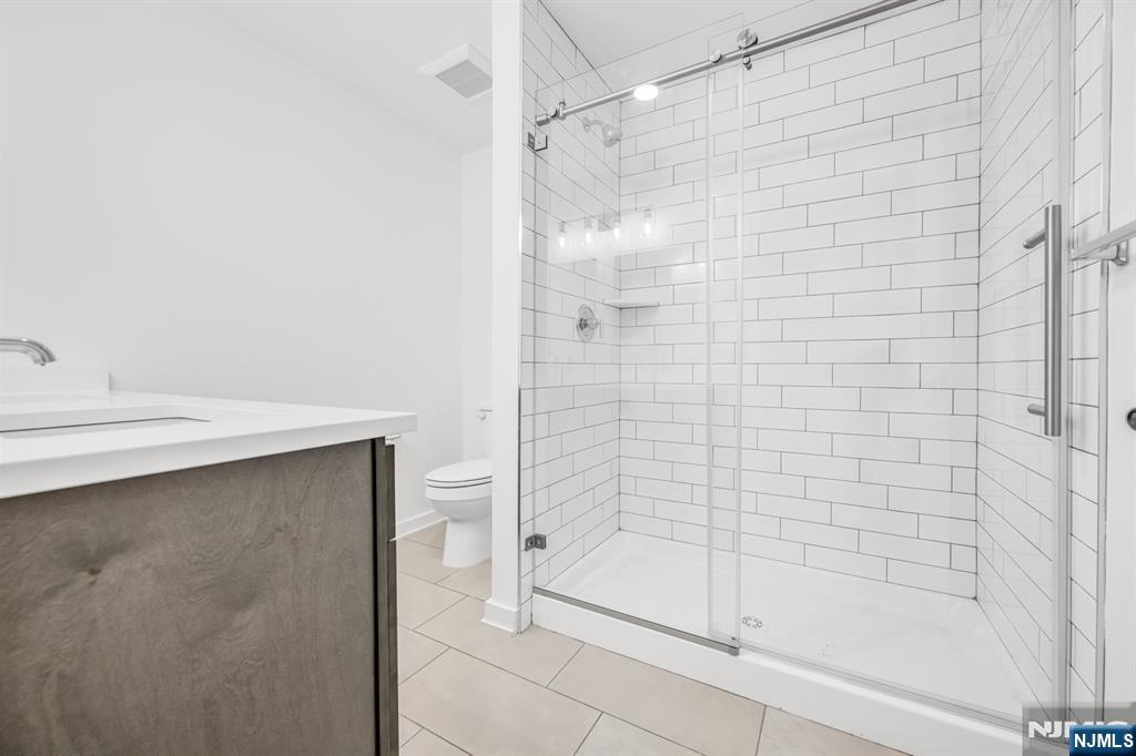 315 Railroad Avenue, Unit 107 East Rutherford, NJ 07073 - Photo 16 of 25 a bathroom with a shower and a glass door