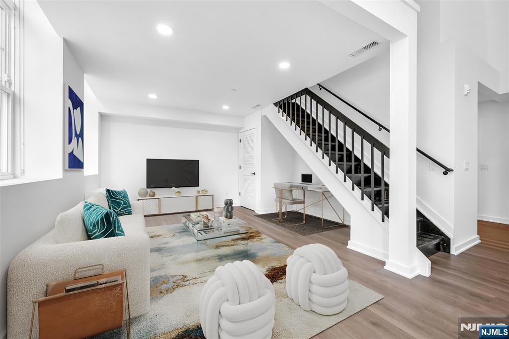315 Railroad Avenue, Unit 107 East Rutherford, NJ 07073 - Photo 3 of 25 a living room with furniture and a flat screen tv