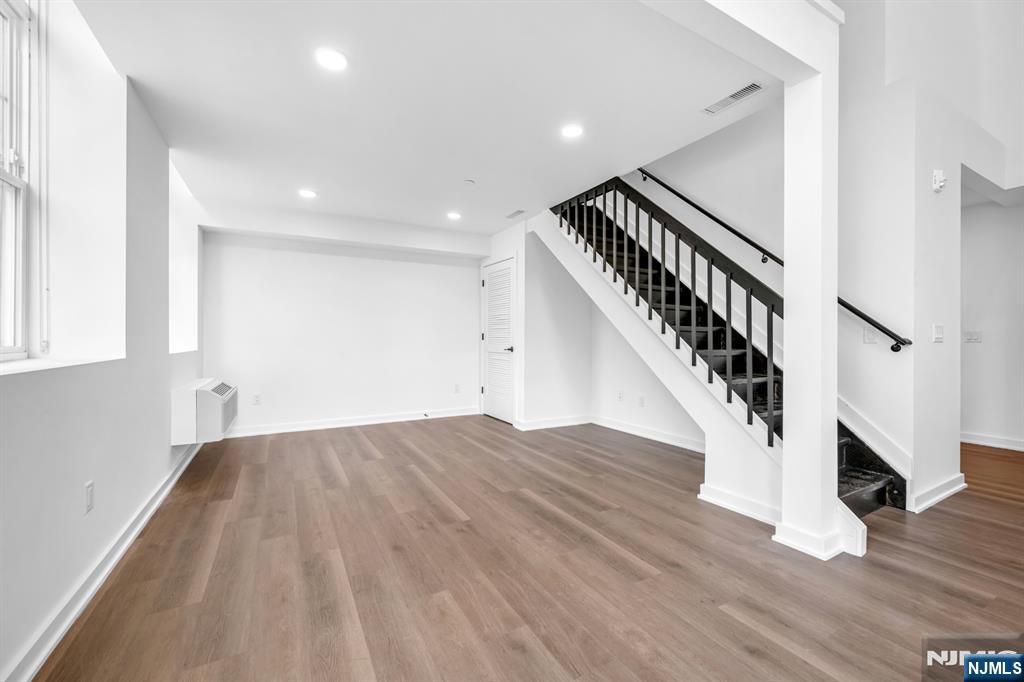315 Railroad Avenue, Unit 107 East Rutherford, NJ 07073 - Photo 4 of 25 a view of staircase with wooden floor and white walls