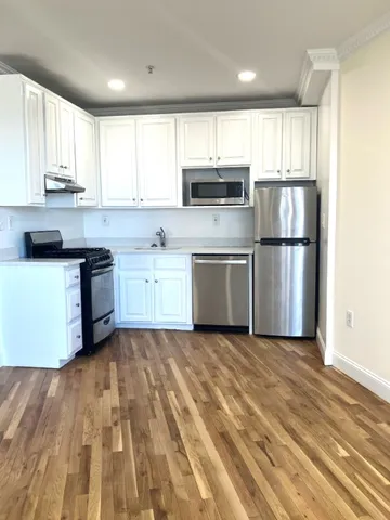 a kitchen with stainless steel appliances granite countertop a stove a sink and a microwave