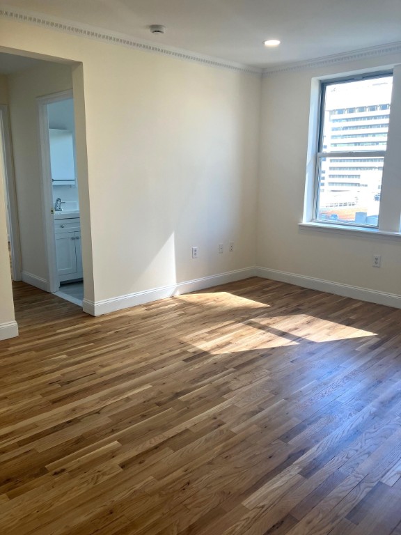 57 Sip Avenue, Unit 7B Jersey City, NJ 07306 - Photo 2 of 5 an empty room with wooden floor & windows