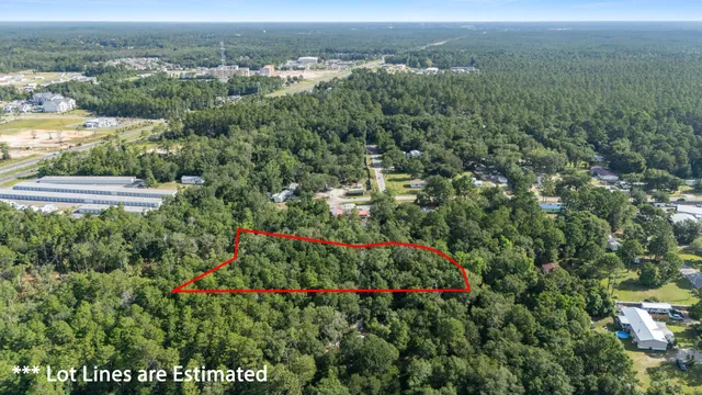 an aerial view of residential house with outdoor space and trees all around