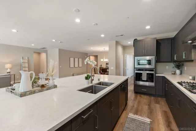 a kitchen with stainless steel appliances kitchen island granite countertop a sink and a refrigerator