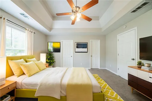 a bedroom with a bed and a flat tv screen on dresser