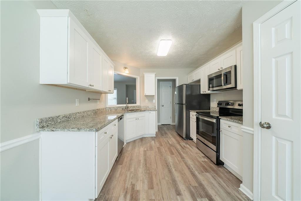 40 Princeton Court Covington, GA 30016 - Photo 10 of 31 a kitchen with granite countertop a refrigerator stove top oven and sink
