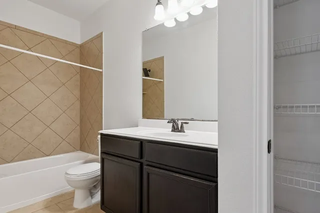 a bathroom with a sink a toilet a mirror and shower