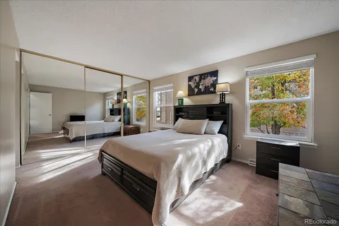 a spacious bedroom with a bed and a dresser next to a window