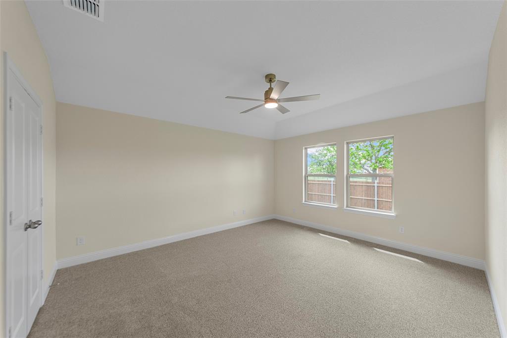 200 Pennington Road Josephine, TX 75173 - Photo 13 of 22 Spacious interior room featuring a tray ceiling, two windows, carpet flooring, and a ceiling fan with integrated lighting