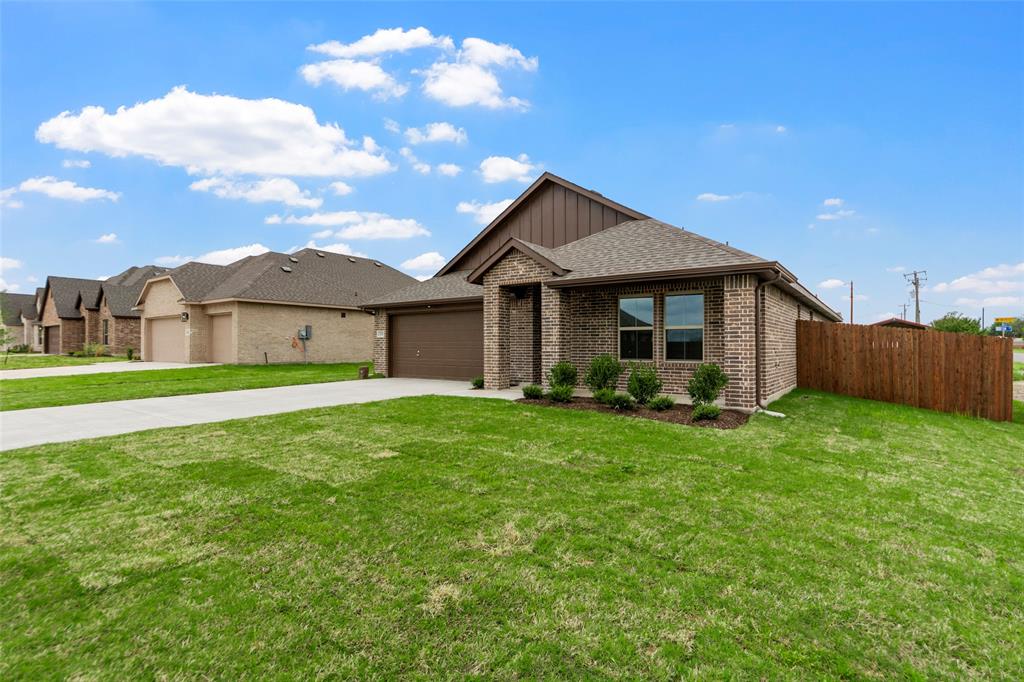 200 Pennington Road Josephine, TX 75173 - Photo 2 of 22 Brick exterior with a two-car garage, brown garage door, and a brown shingle roof