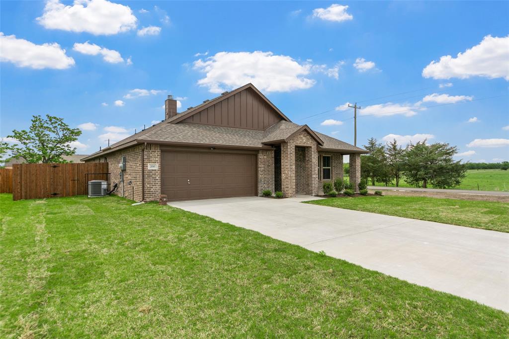 200 Pennington Road Josephine, TX 75173 - Photo 3 of 22 Brick exterior with a prominent two-car garage, concrete driveway, and covered front entry