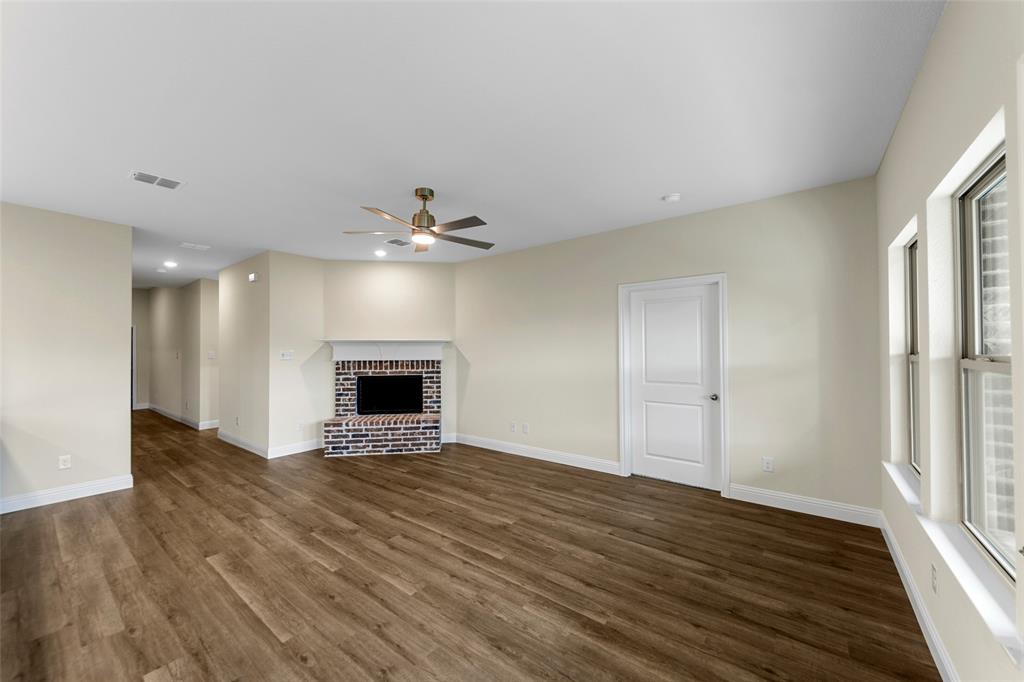 200 Pennington Road Josephine, TX 75173 - Photo 4 of 22 Spacious interior room featuring wood-finish flooring, a brick fireplace with a white mantle, an overhead ceiling fan, recessed lighting, and multiple windows