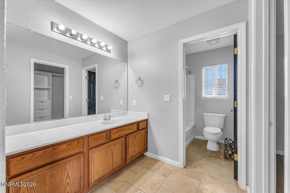 17725 Gingko Court Reno, NV 89508 - Photo 22 of 37 a spacious bathroom with a granite countertop sink a toilet and a mirror