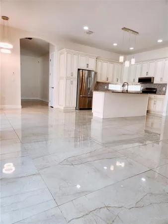 a view of kitchen with refrigerator and cabinets