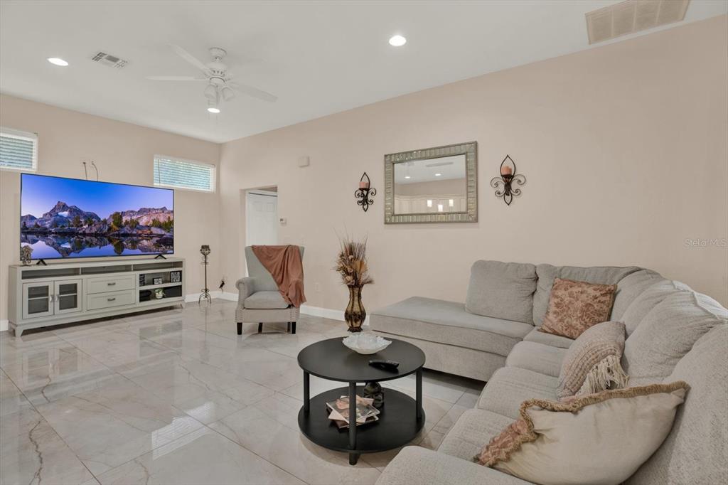 7190 Raymond Place Spring Hill, FL 34607 - Photo 13 of 41 a living room with furniture and a flat screen tv