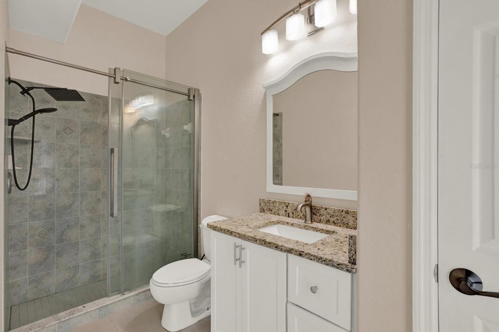 7190 Raymond Place Spring Hill, FL 34607 - Photo 28 of 41 a bathroom with a granite countertop sink toilet and shower