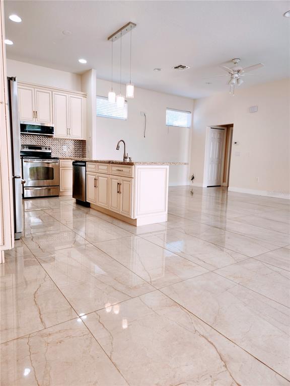 7190 Raymond Place Spring Hill, FL 34607 - Photo 9 of 41 a large kitchen with stainless steel appliances and cabinets