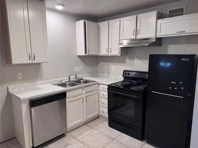 a kitchen with white cabinets and appliances