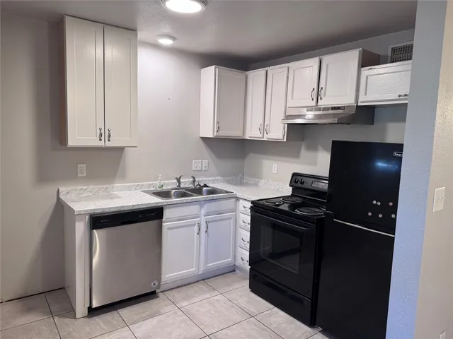a kitchen with cabinets appliances and a sink
