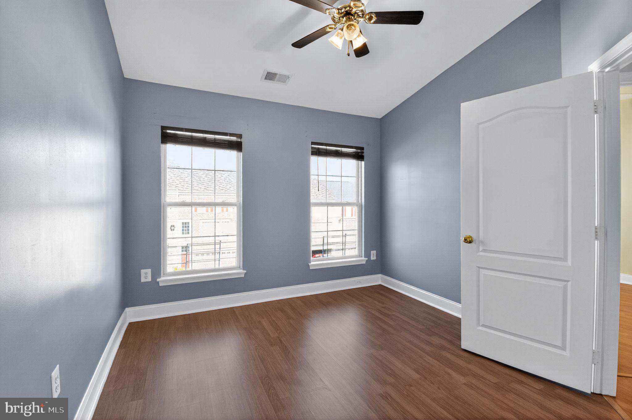 16567 Bramblewood Lane Woodbridge, VA 22191 - Photo 8 of 15 an empty room with wooden floor chandelier fan and windows