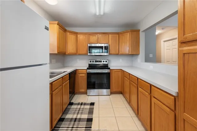 a kitchen with a sink a stove top oven and cabinets