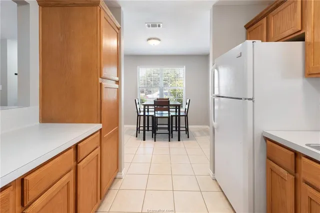 a kitchen with stainless steel appliances a refrigerator and a table