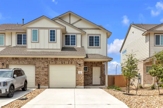 a front view of a house with cars parked