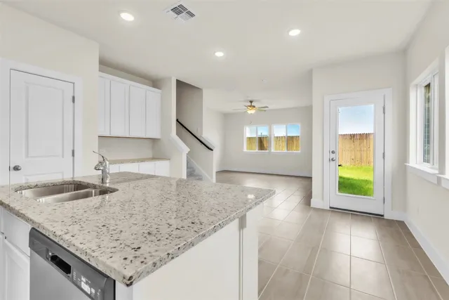 a kitchen with granite countertop sink and cabinets