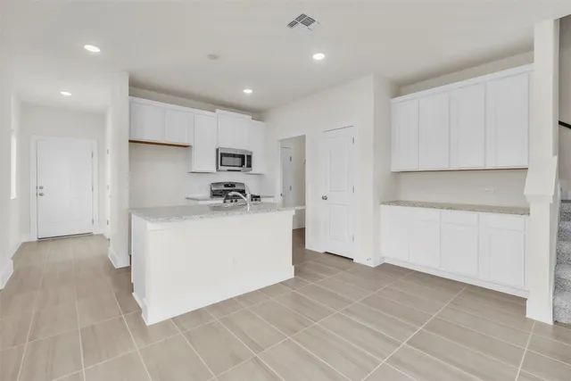 a view of kitchen with white cabinets