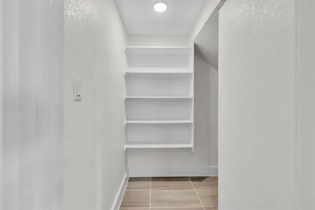 a view of walk in closet with empty racks