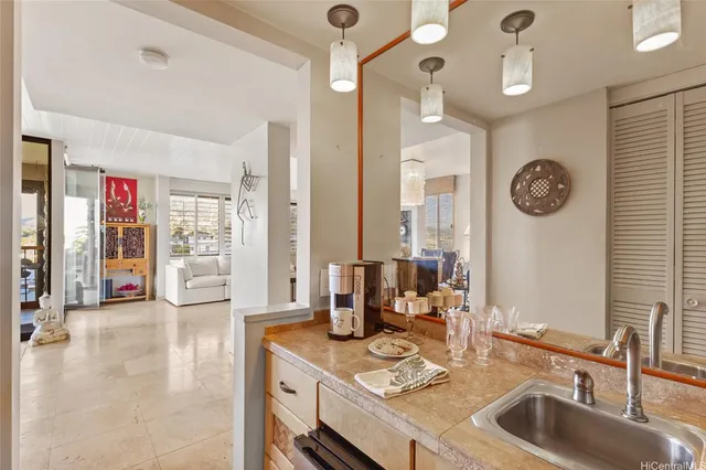 a very nice looking open kitchen with granite countertop a sink cabinets and a large window
