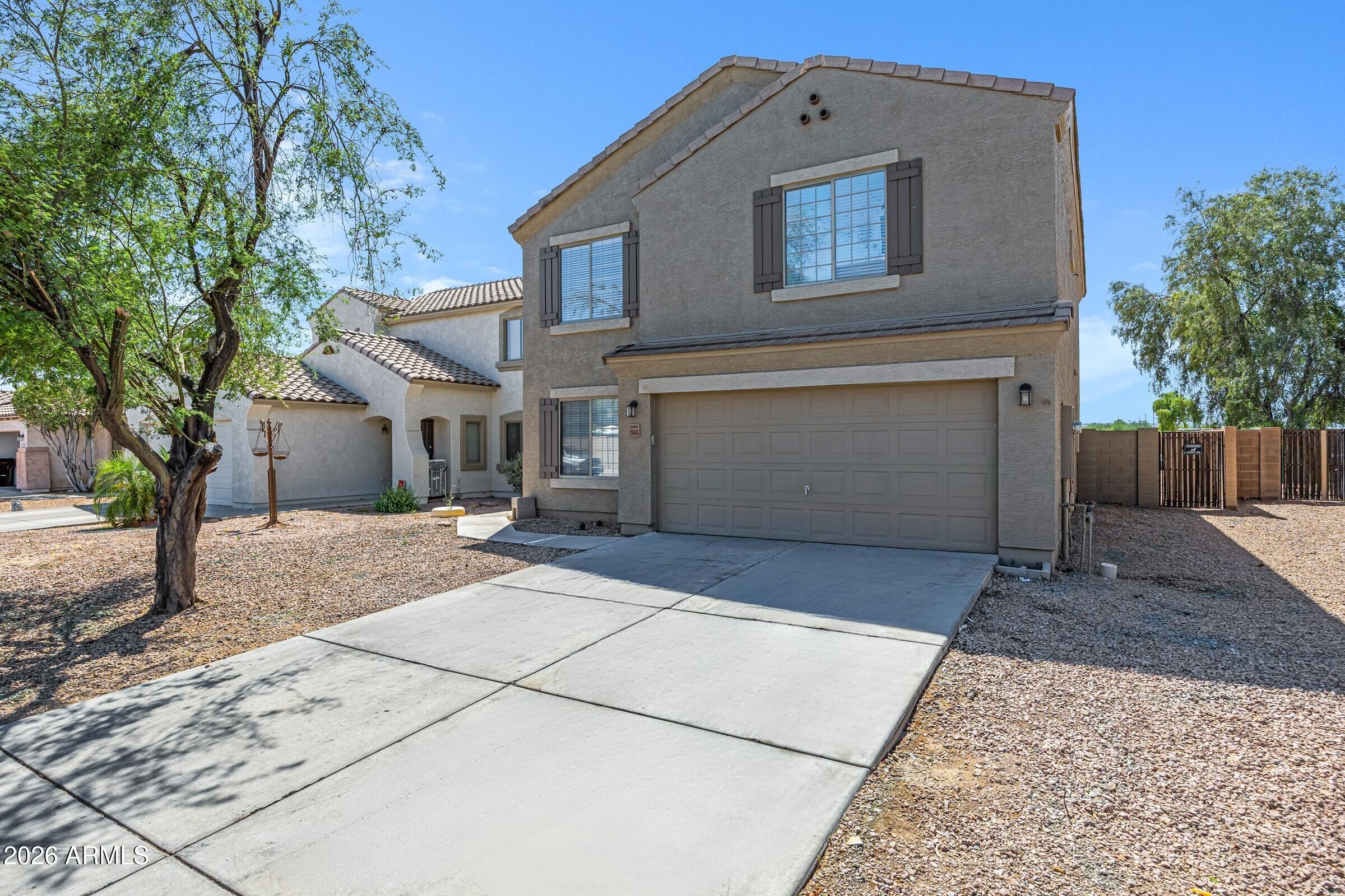 19408 North Braden Road Maricopa, AZ 85138 - Photo 2 of 51 a front view of a house with a yard and garage