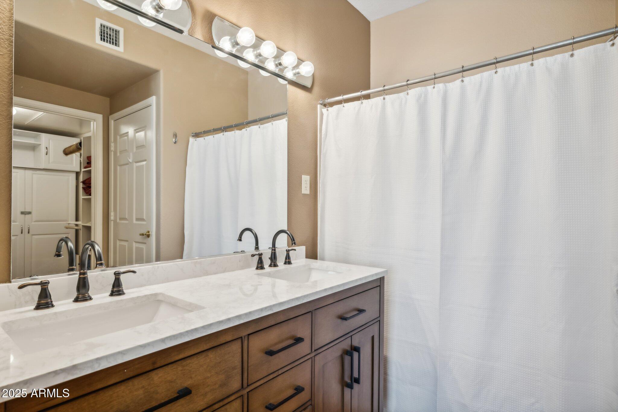 6535 East Superstition Springs Boulevard, Unit 109 Mesa, AZ 85206 - Photo 14 of 26 a bathroom with a double vanity sink and a mirror