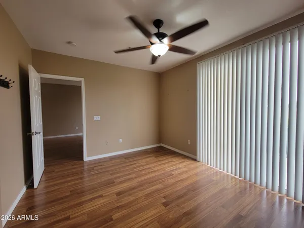 a view of a hallway with wooden floor and bathroom