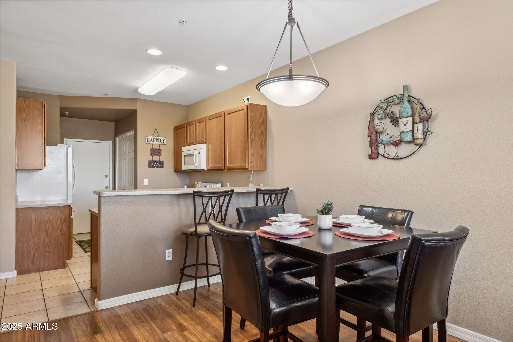 6535 East Superstition Springs Boulevard, Unit 109 Mesa, AZ 85206 - Photo 7 of 26 a view of a dining room with furniture wooden floor and a chandelier